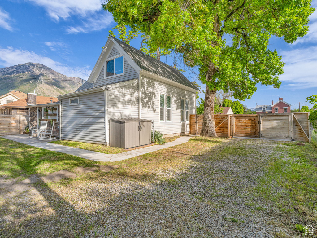 Back of house with a gate, a mountain view, and a patio