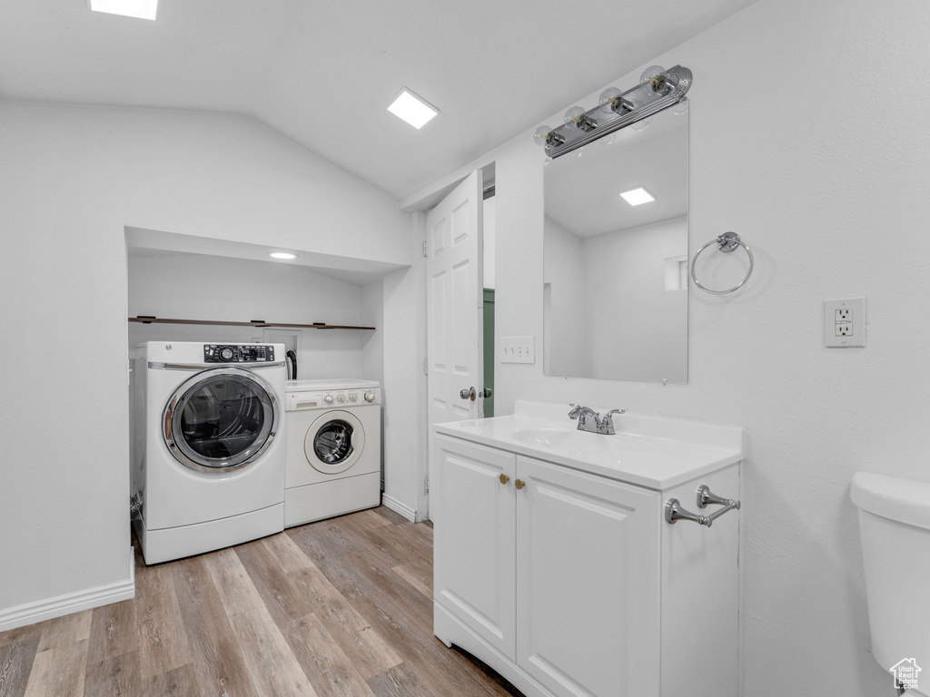 Laundry area featuring separate washer and dryer and light wood-style floors