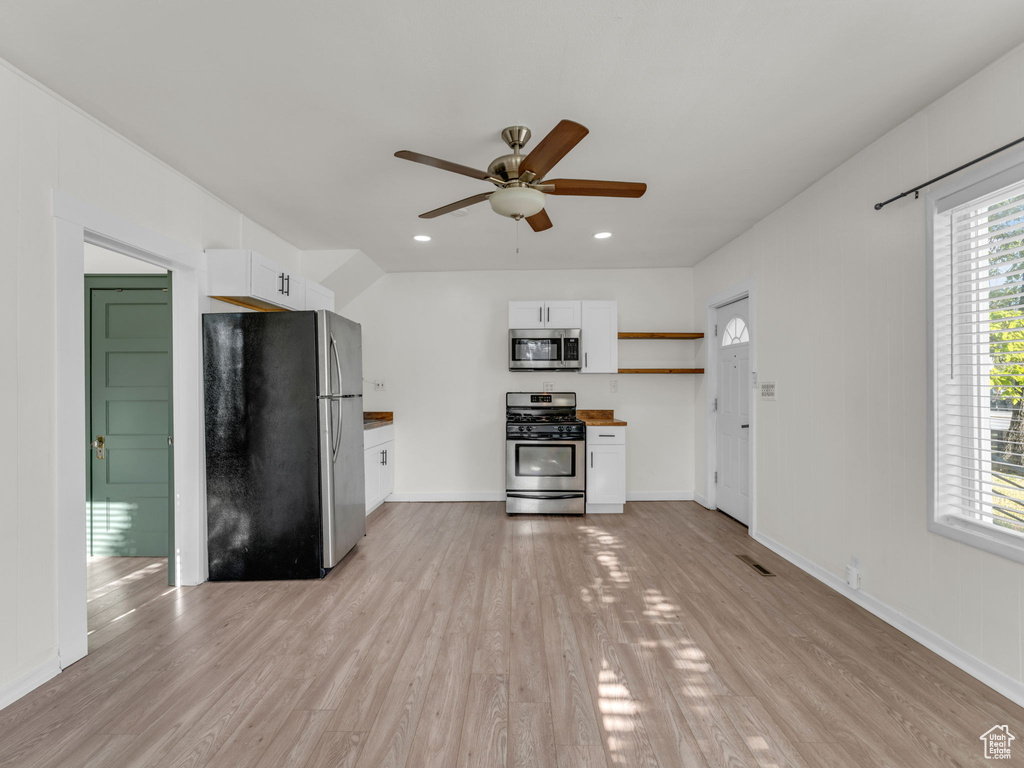 Kitchen featuring stainless steel appliances, a ceiling fan, white cabinets, light wood-style flooring, and open shelves