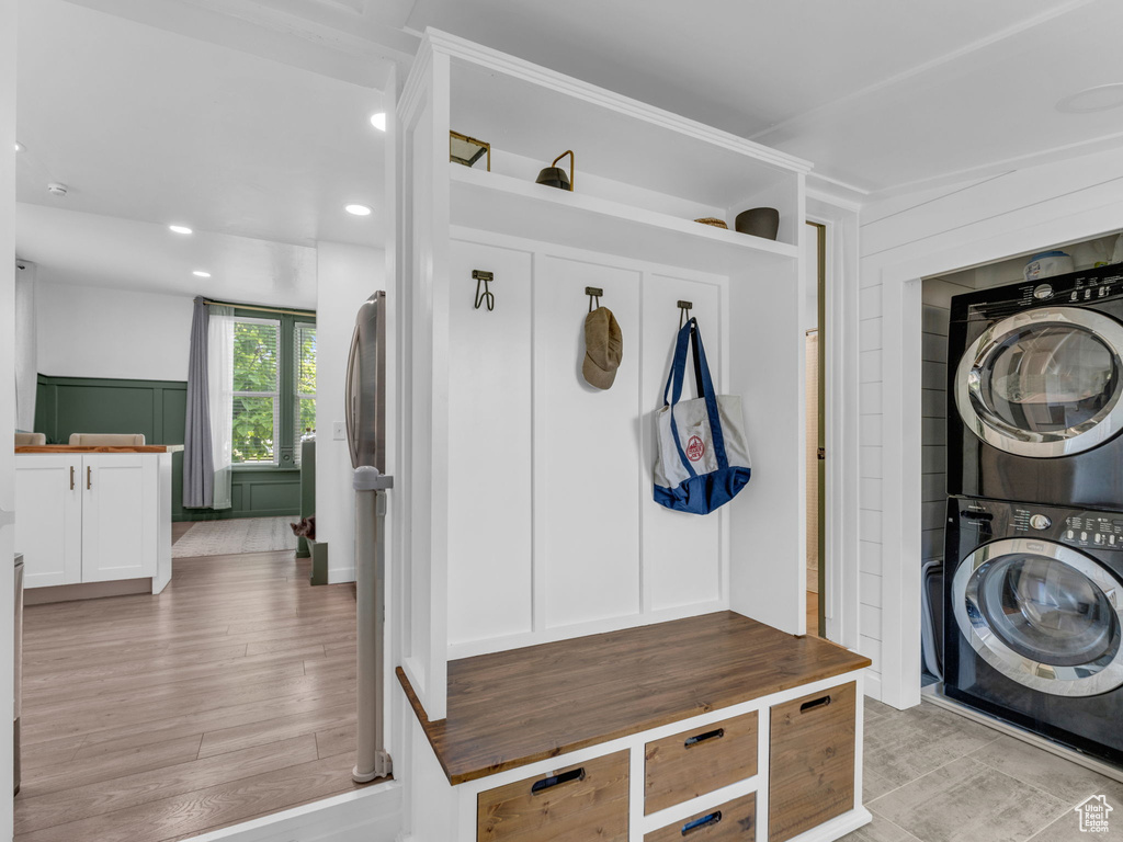 Mudroom with stacked washer / dryer, a decorative wall, recessed lighting, and light wood finished floors