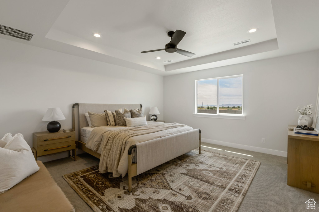 Bedroom featuring a tray ceiling, recessed lighting, light colored carpet, and ceiling fan