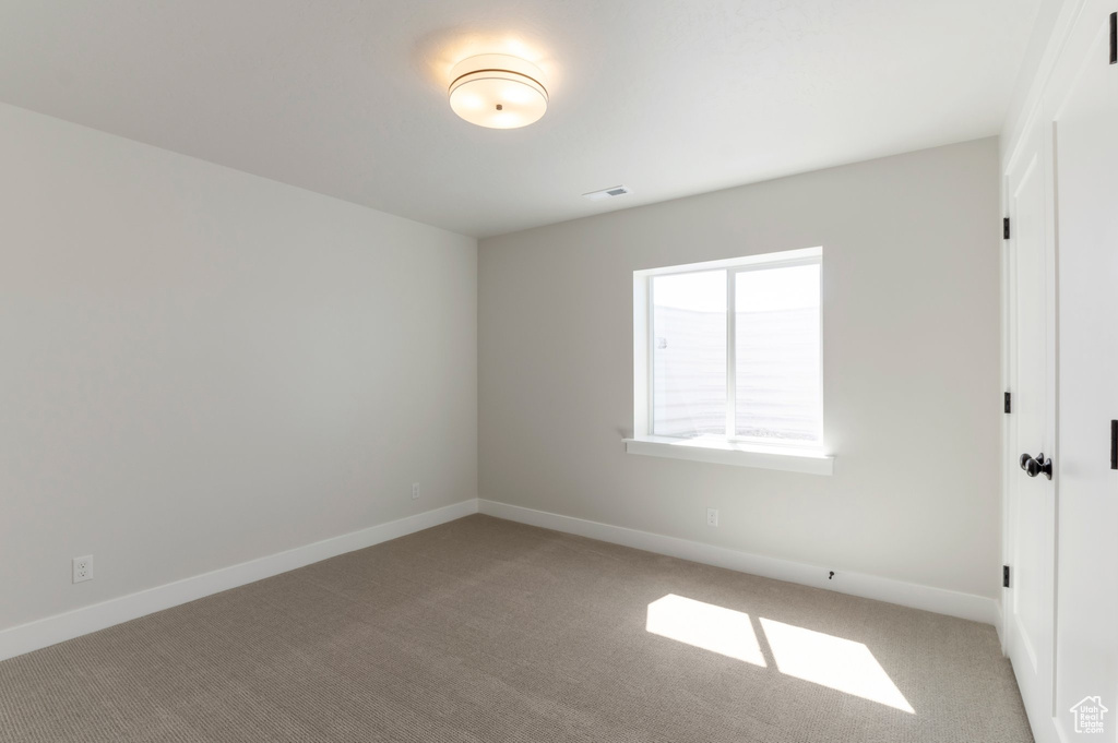 Spare room with light colored carpet and baseboards