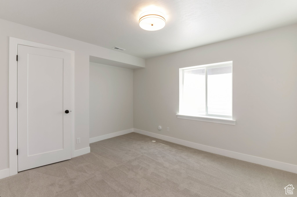 Unfurnished bedroom with light carpet and baseboards