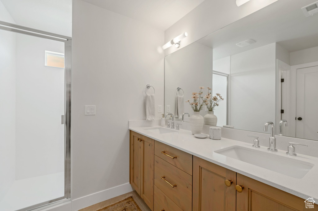 Bathroom with double vanity and a shower stall