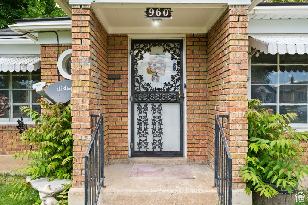 Entrance to property with brick siding and covered porch