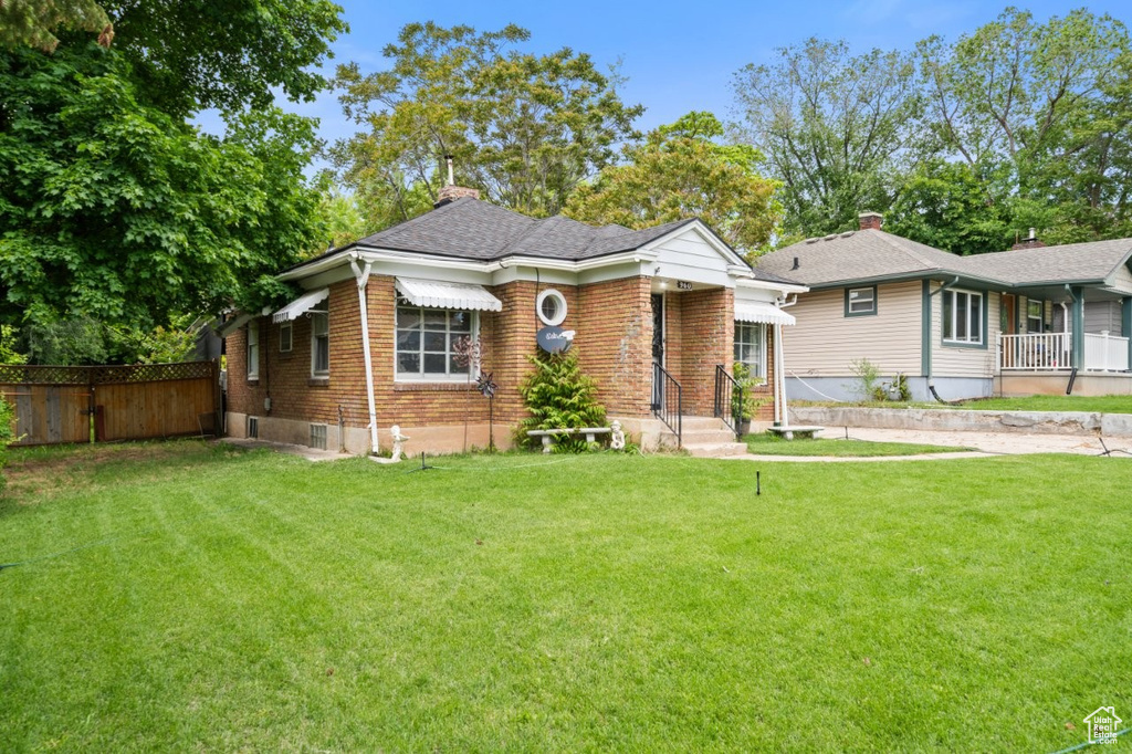 Bungalow-style home featuring brick siding and a chimney