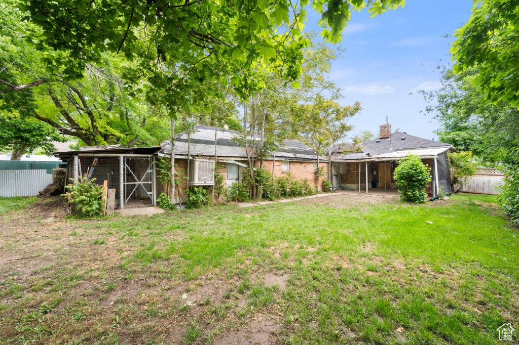 Back of property with a chimney and an outdoor structure