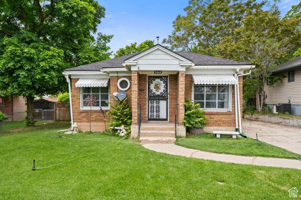 Bungalow with brick siding and a shingled roof