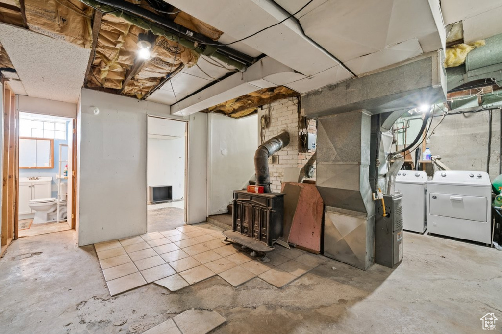 Below grade area with washer and dryer, a wood stove, and heating unit