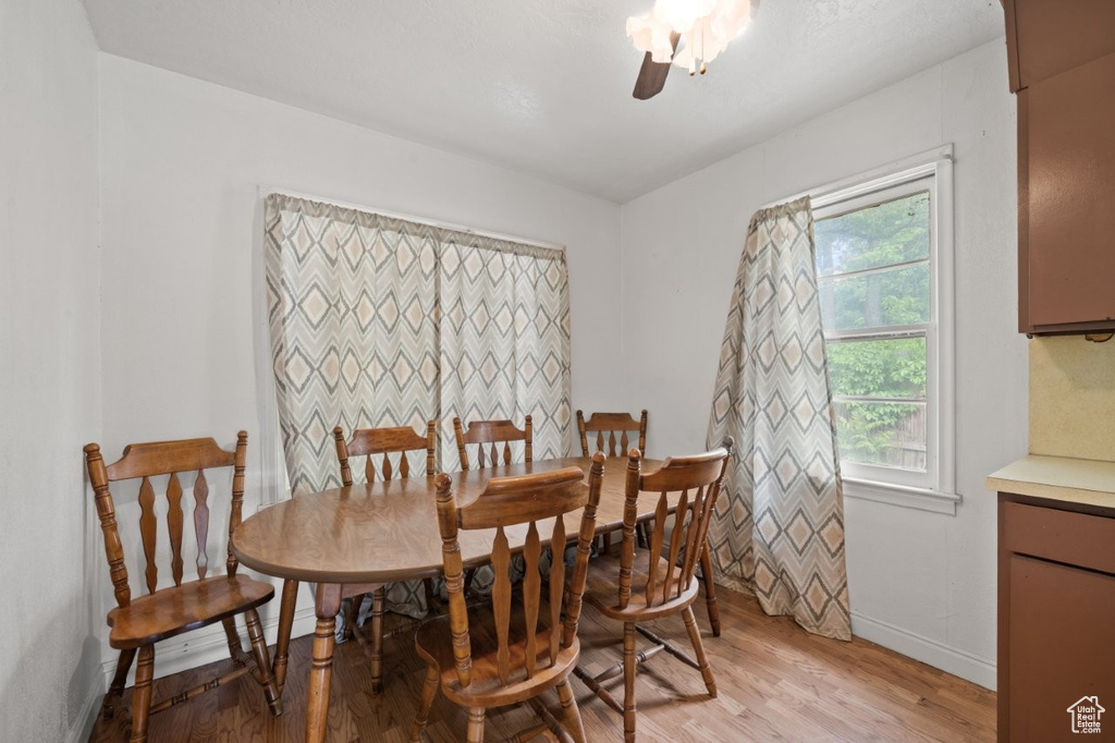 Dining area featuring light wood finished floors, baseboards, and a ceiling fan