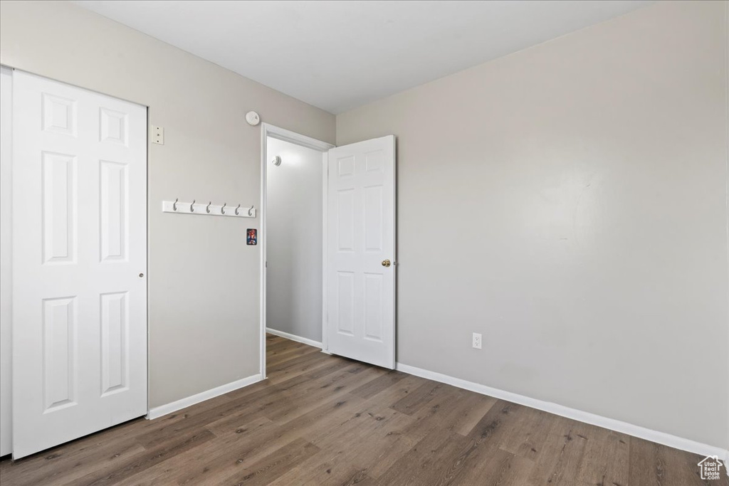 Unfurnished bedroom featuring wood finished floors and baseboards
