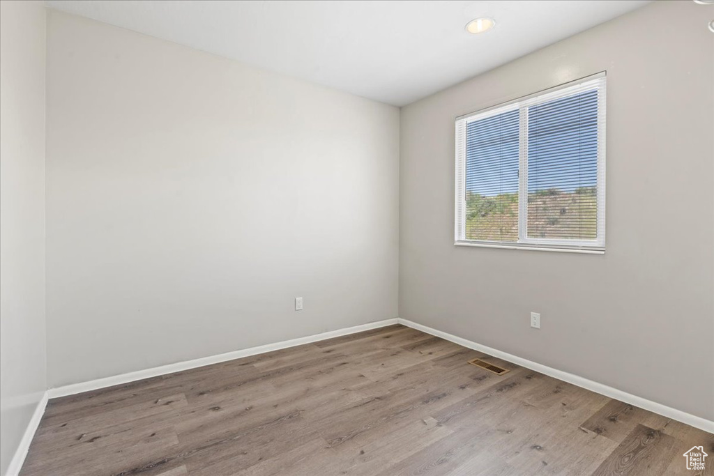 Spare room with wood finished floors, baseboards, and recessed lighting