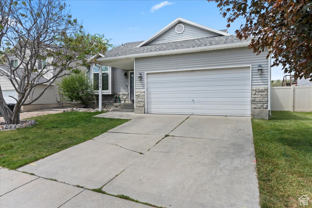 Ranch-style home with a garage, concrete driveway, and a shingled roof