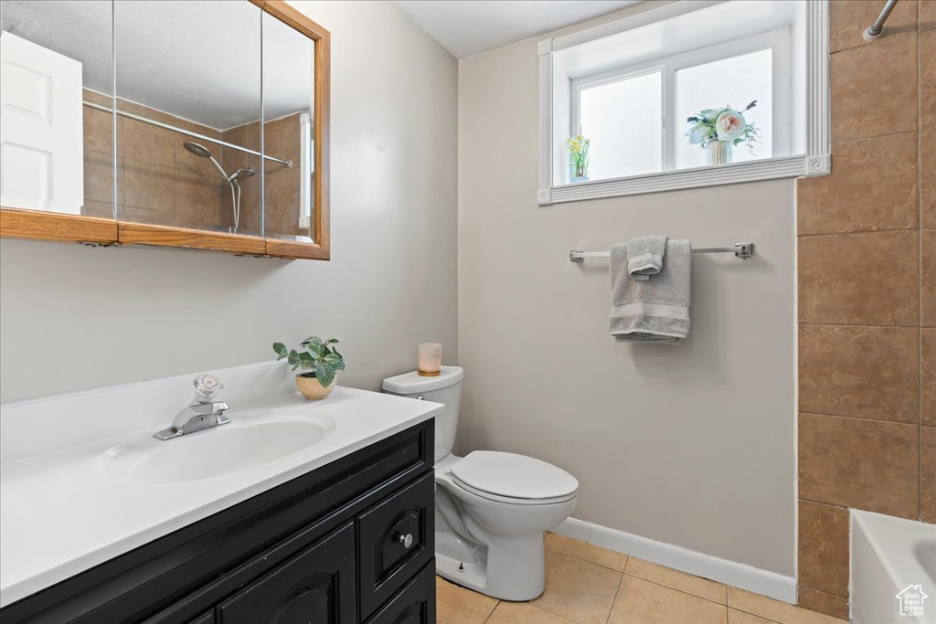 Bathroom with toilet, tile patterned flooring, baseboards, and vanity