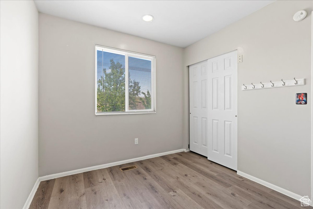 Unfurnished bedroom with wood finished floors, baseboards, a closet, and recessed lighting