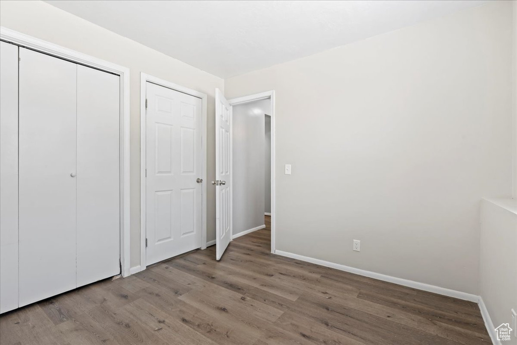 Unfurnished bedroom featuring baseboards and wood finished floors