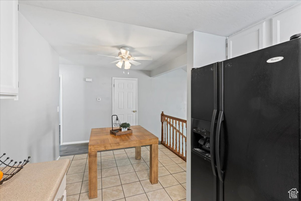 Dining area with a ceiling fan, light tile patterned flooring, and baseboards