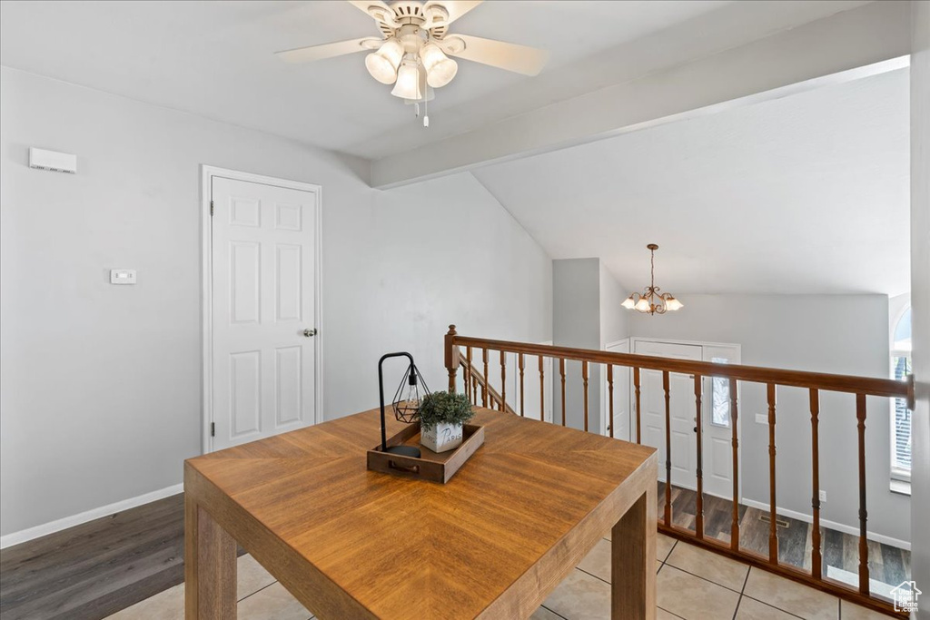 Dining room with a ceiling fan, a chandelier, light wood-style flooring, and baseboards