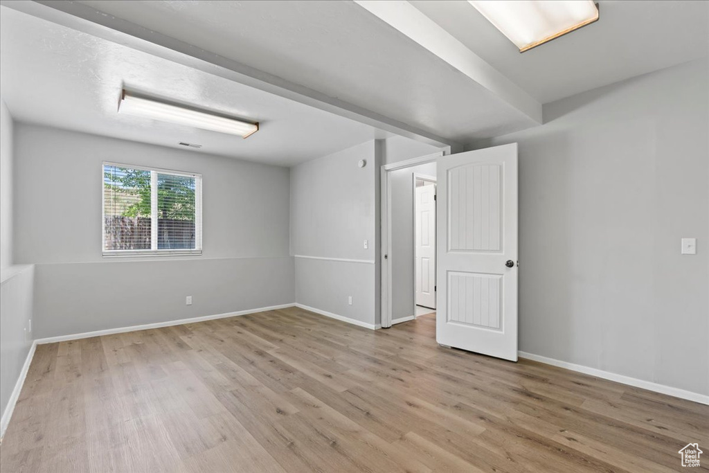 Unfurnished room with wood finished floors and baseboards