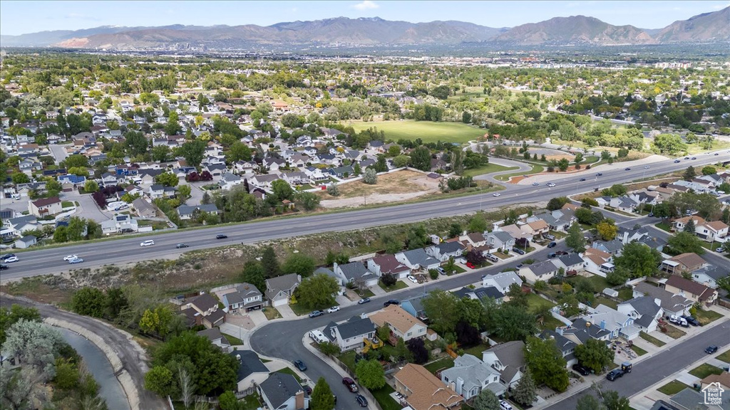 Aerial view of property and surrounding area with mountains and nearby suburban area