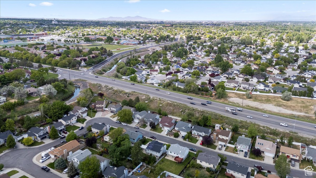 Aerial view of property's location with nearby suburban area and a mountainous background