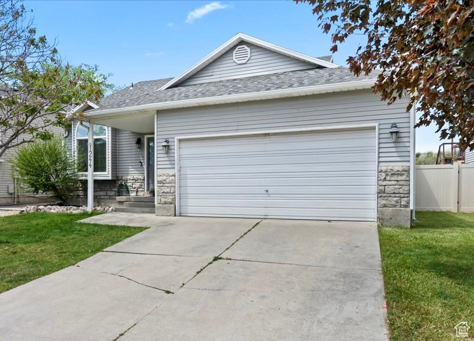 View of front of house featuring stone siding, a garage, concrete driveway, and roof with shingles