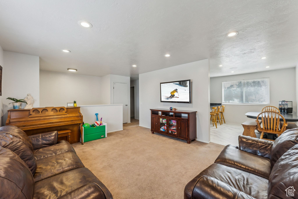 Living area with recessed lighting and light colored carpet