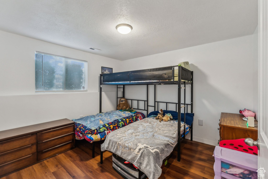 Bedroom featuring wood finished floors and a textured ceiling