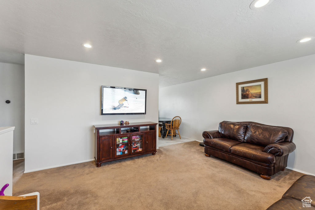 Living room with light carpet, recessed lighting, and baseboards
