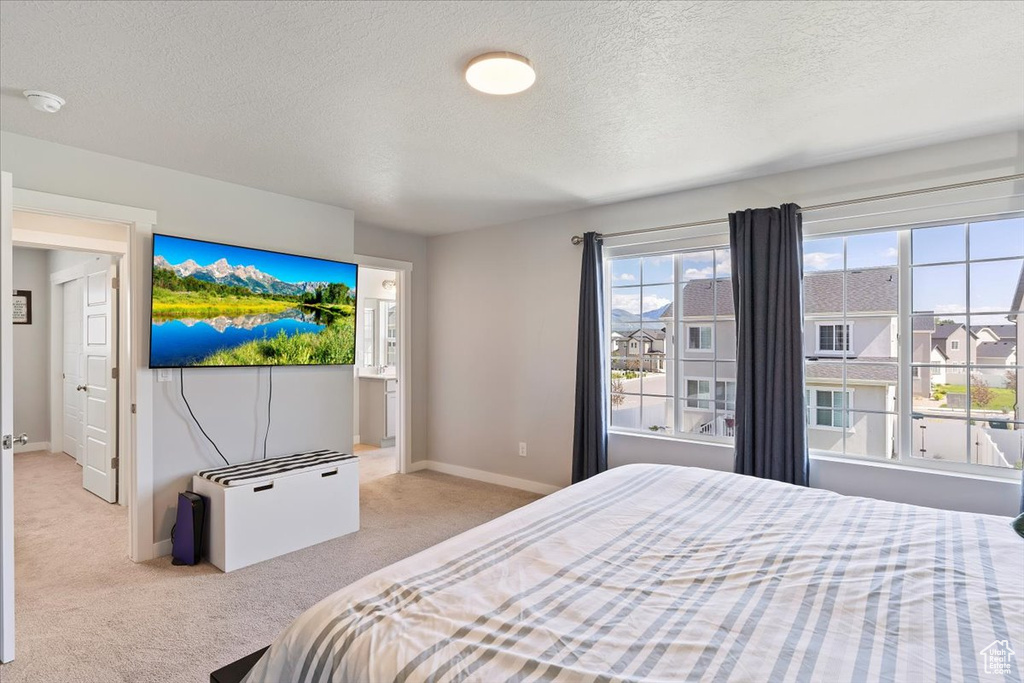 Carpeted bedroom featuring a textured ceiling and baseboards