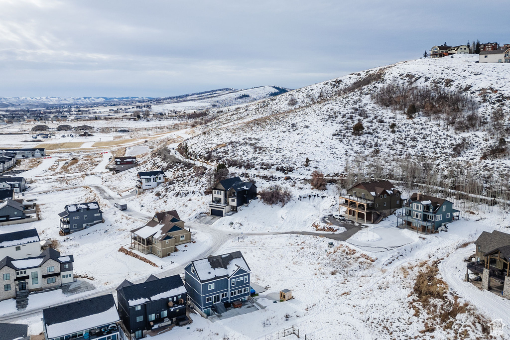 Snowy aerial view featuring a mountain view and a residential view
