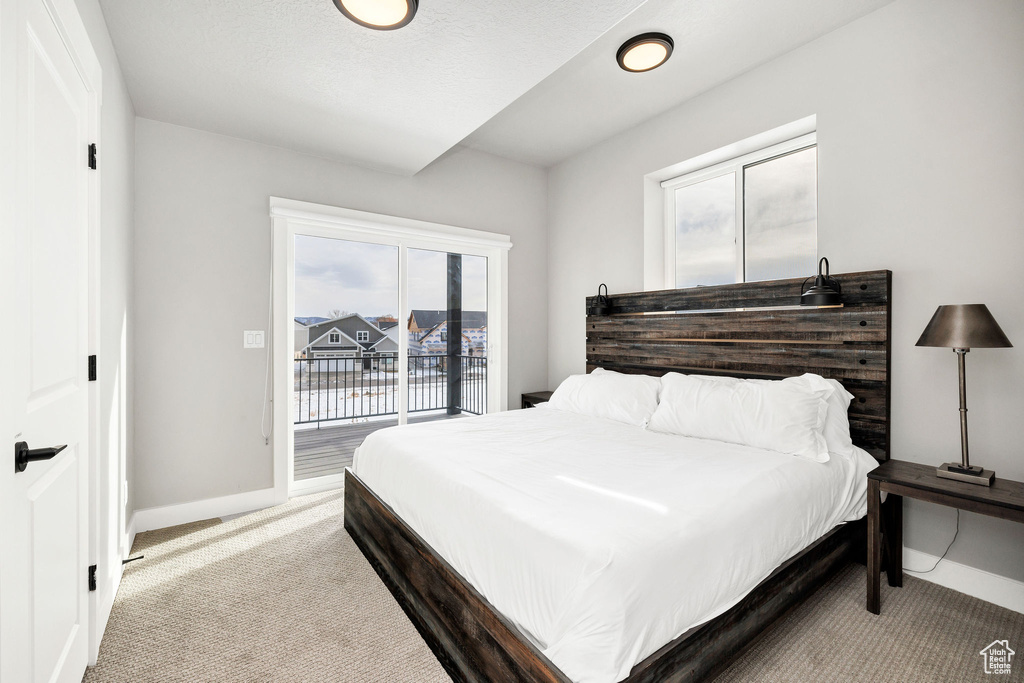 Carpeted bedroom with access to exterior and baseboards