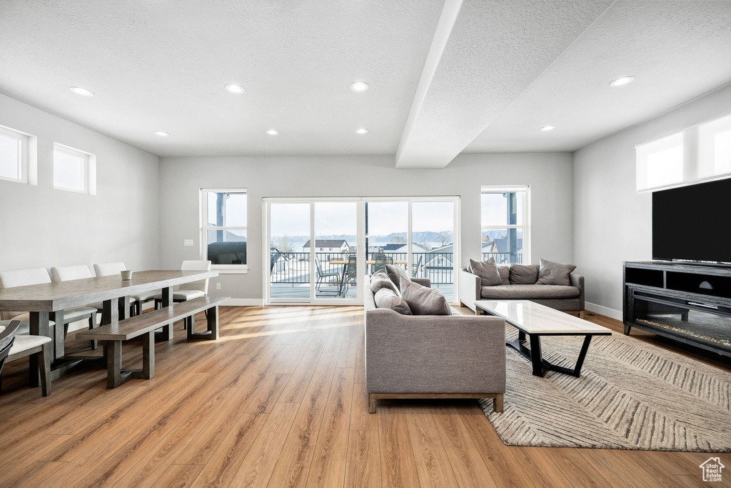 Living room featuring light wood finished floors, recessed lighting, healthy amount of natural light, and baseboards