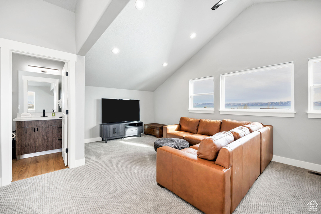 Living room featuring carpet floors, vaulted ceiling, recessed lighting, and baseboards