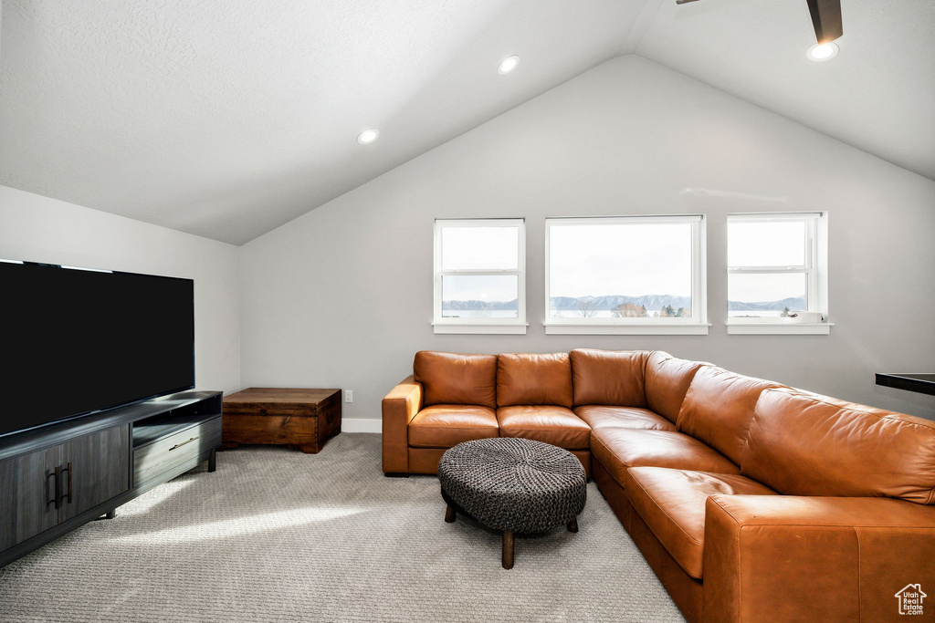 Carpeted living room featuring vaulted ceiling, recessed lighting, and ceiling fan