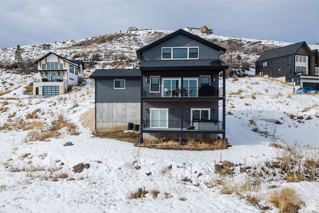 Snow covered property with a balcony
