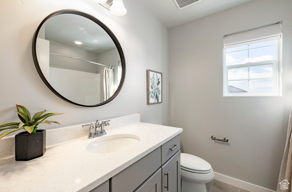 Full bath featuring toilet, vanity, tile patterned floors, and a shower with shower curtain
