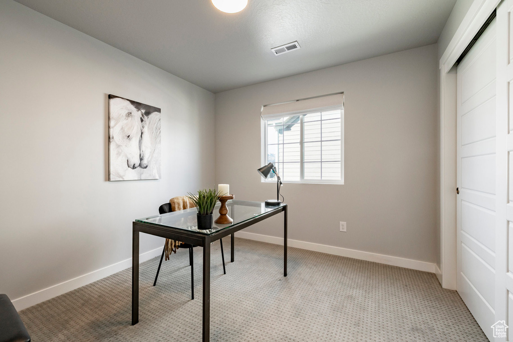 Home office featuring light colored carpet and baseboards
