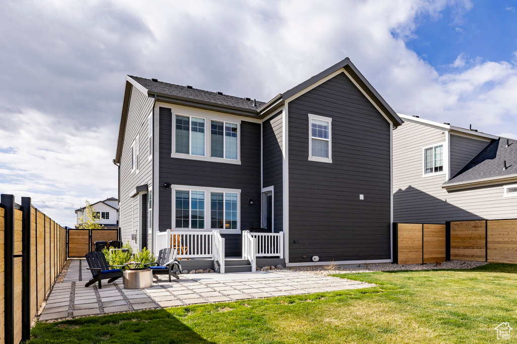 Back of house with a patio and a fire pit