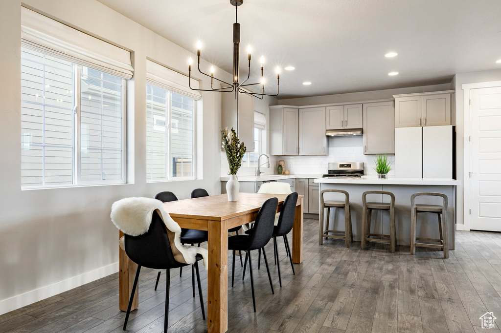 Dining room featuring a chandelier, dark wood-type flooring, recessed lighting, and baseboards