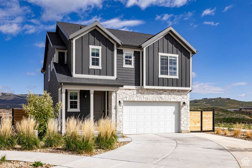 View of front facade featuring board and batten siding, stone siding, and a mountain view