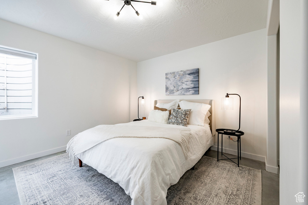 Bedroom with finished concrete floors and baseboards