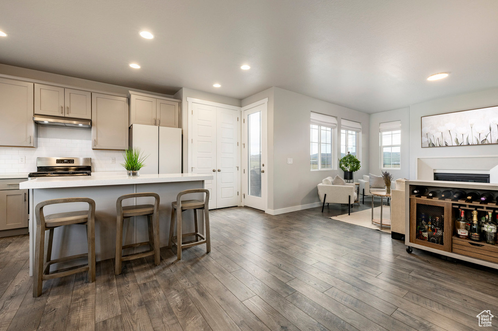 Kitchen featuring freestanding refrigerator, gray cabinetry, stainless steel electric stove, under cabinet range hood, and light countertops