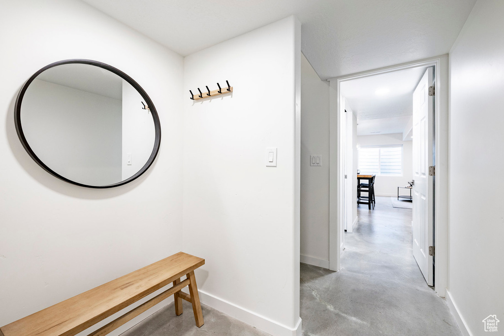 Hall featuring concrete flooring and baseboards