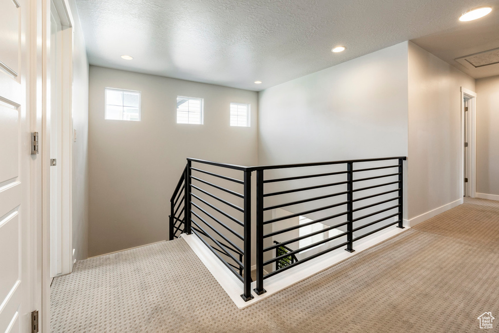 Stairway with carpet flooring, recessed lighting, a textured ceiling, and baseboards
