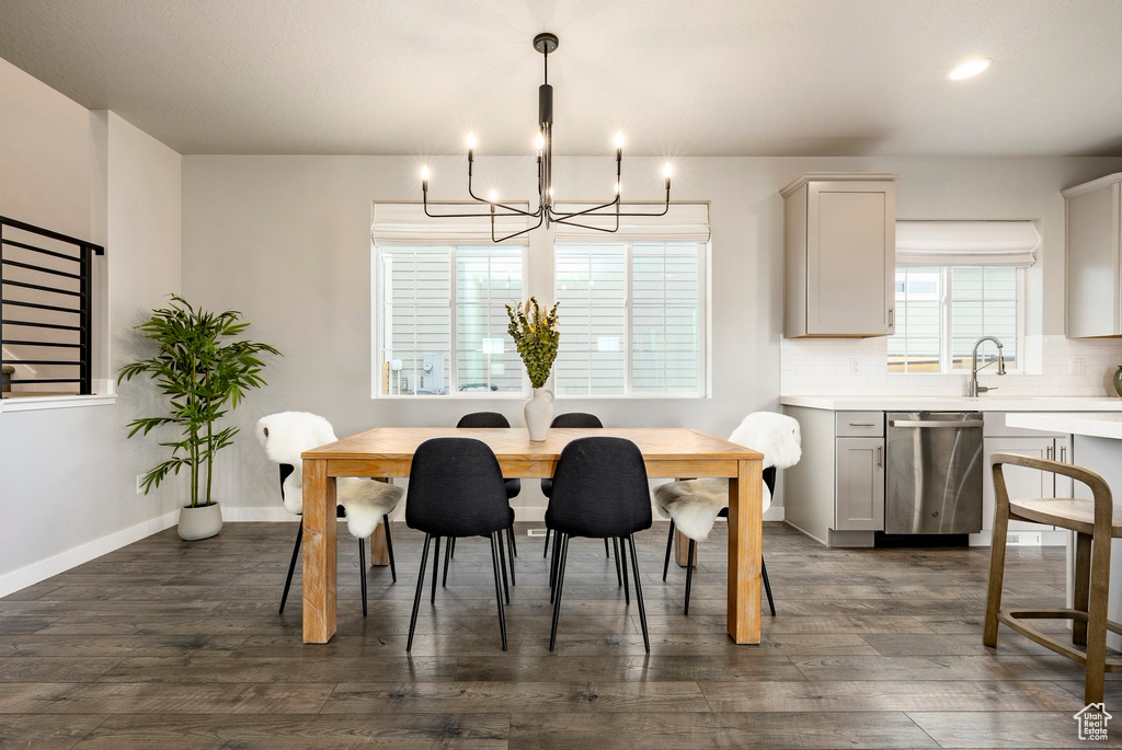 Dining space featuring a chandelier, dark wood finished floors, baseboards, and recessed lighting