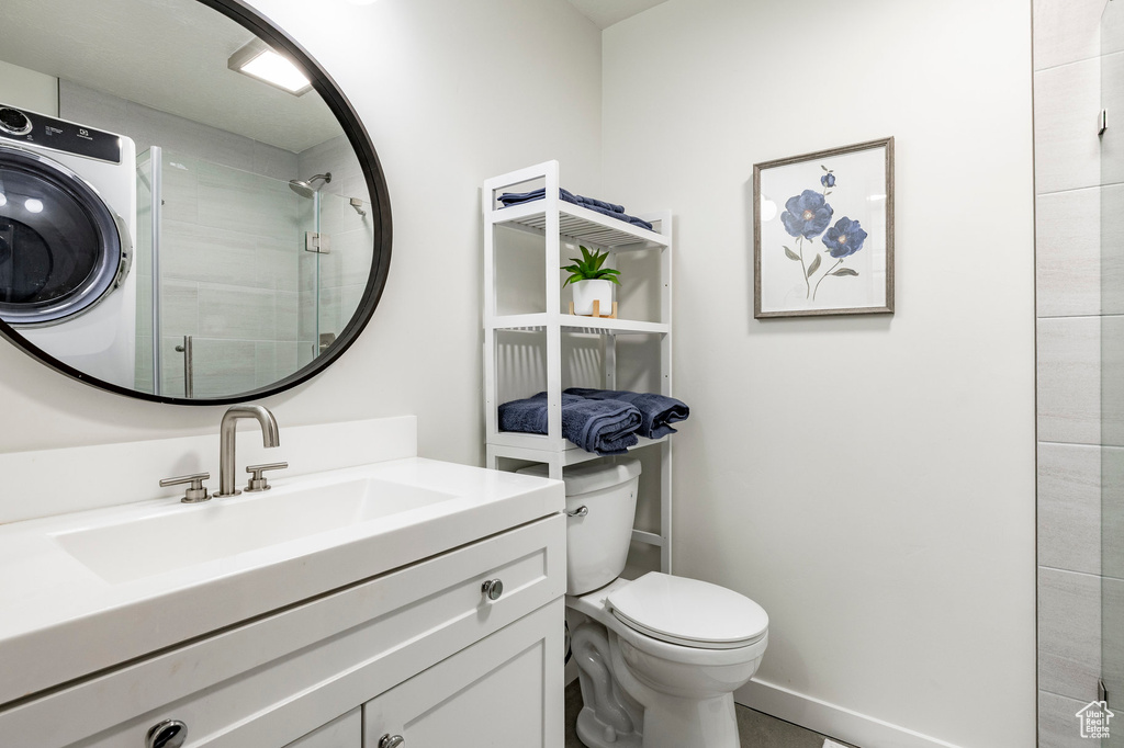 Bathroom with toilet, vanity, and tiled shower