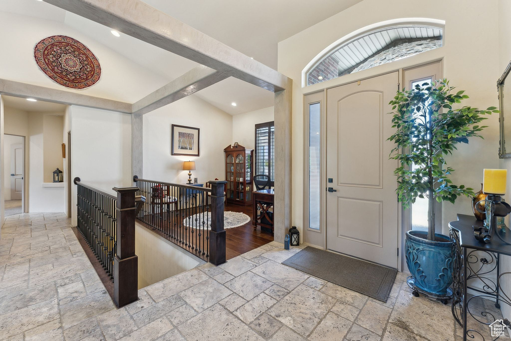 Entrance foyer with stone tile floors, lofted ceiling, and recessed lighting