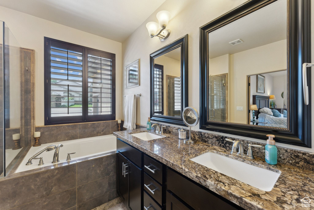 Bathroom with a bath, double vanity, and connected bathroom