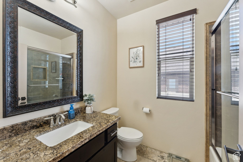 Full bathroom with an enclosed shower, toilet, and vanity